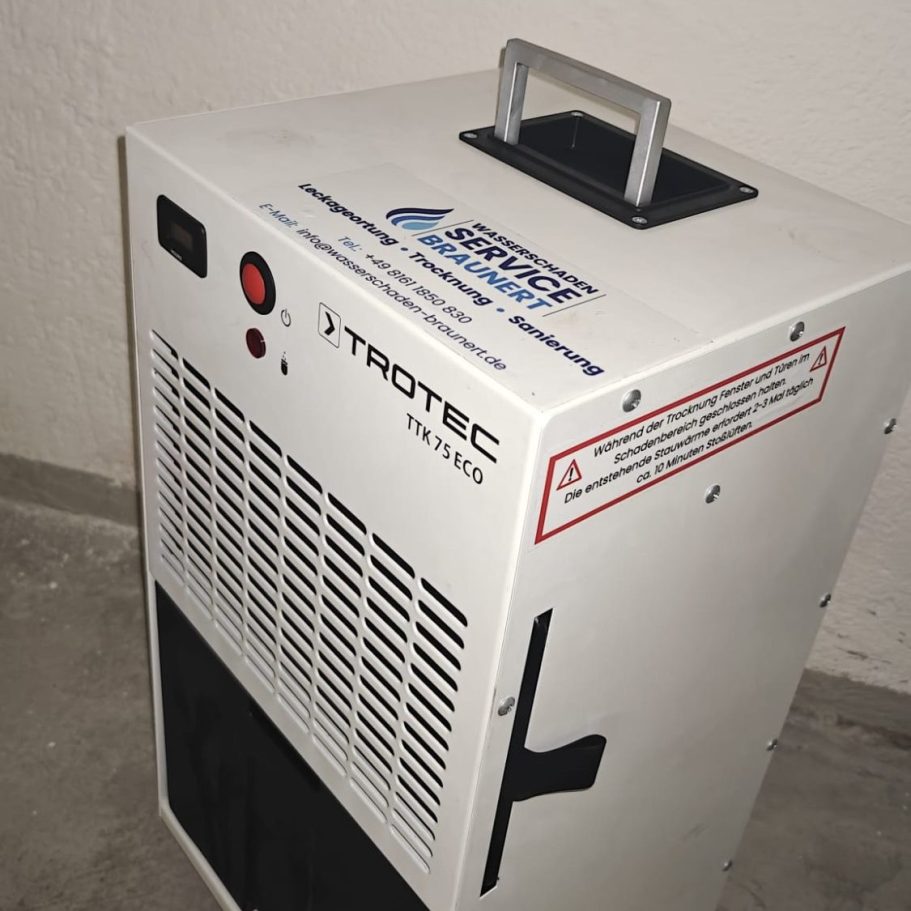 Trocknungsgerät der Firma Wasserschaden-Service Braunert Mobiler Luftentfeuchter von Trotec, weiß mit Griff und Steuerfeld.